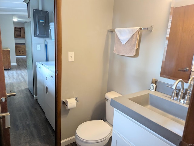bathroom featuring vanity, separate washer and dryer, toilet, baseboards, and wood finished floors