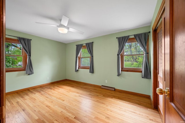 empty room with ceiling fan, baseboards, plenty of natural light, and light wood-style flooring