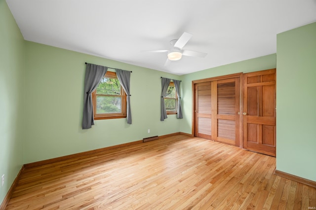 unfurnished bedroom featuring baseboards, light wood finished floors, and a closet