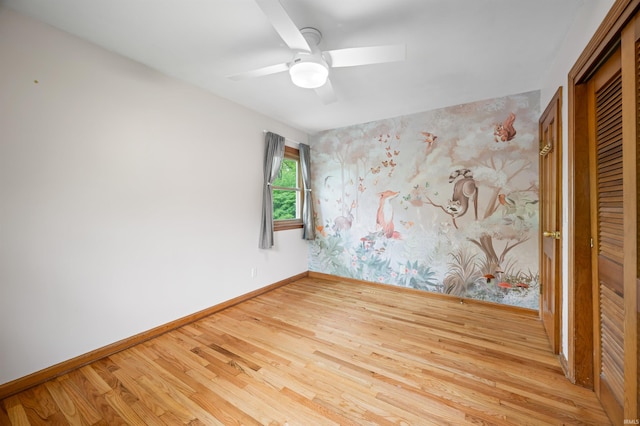 unfurnished room featuring baseboards, ceiling fan, wallpapered walls, and wood finished floors