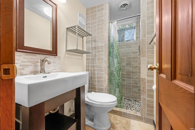 full bath featuring visible vents, decorative backsplash, toilet, and tiled shower