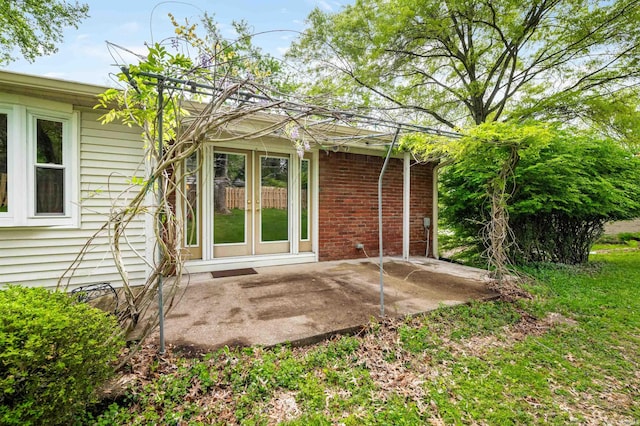 rear view of house featuring french doors, a patio area, and brick siding