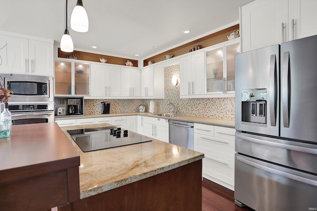 kitchen with stainless steel appliances, decorative light fixtures, white cabinetry, backsplash, and glass insert cabinets