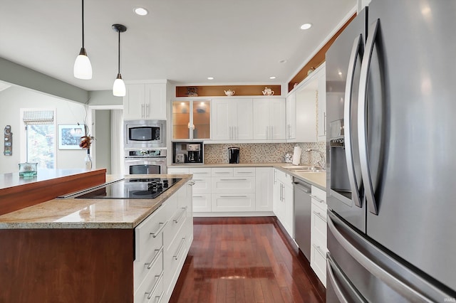 kitchen featuring decorative backsplash, dark wood finished floors, a sink, glass insert cabinets, and stainless steel appliances