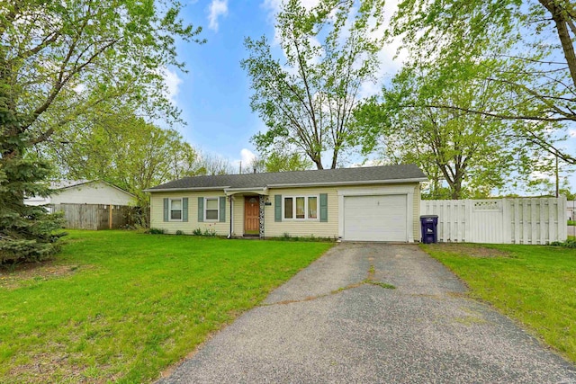 ranch-style home with a garage, fence, driveway, and a front yard
