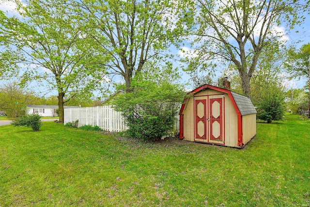 view of yard featuring a storage unit, an outdoor structure, and fence
