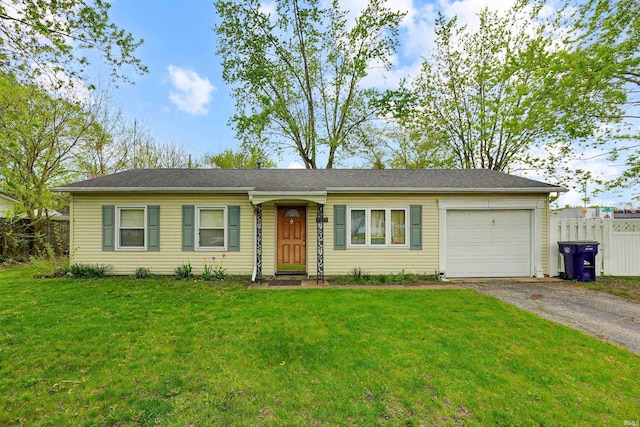 ranch-style home with a garage, aphalt driveway, fence, and a front yard