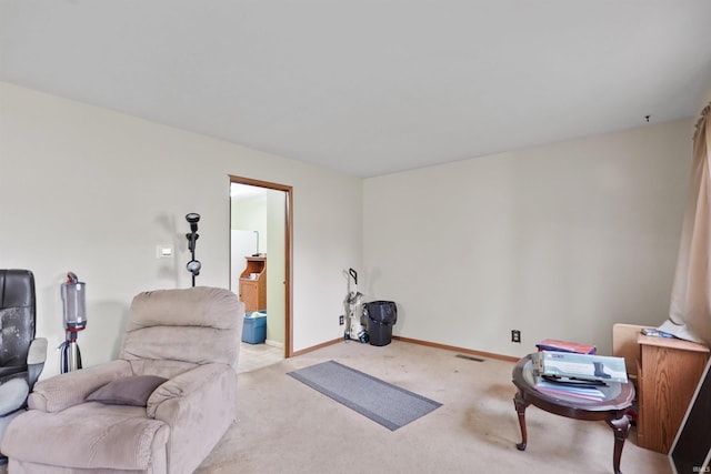 sitting room with baseboards and light colored carpet