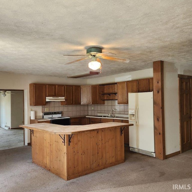 3566 W Sycamore Ln Unit 57, Columbia City, IN 46725 - kitchen featuring white appliances, under cabinet range hood, carpet floors, and light countertops