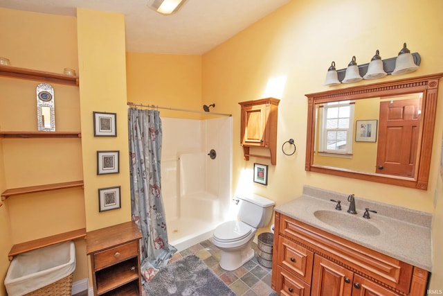 full bath featuring vanity, toilet, stone finish floor, and a stall shower