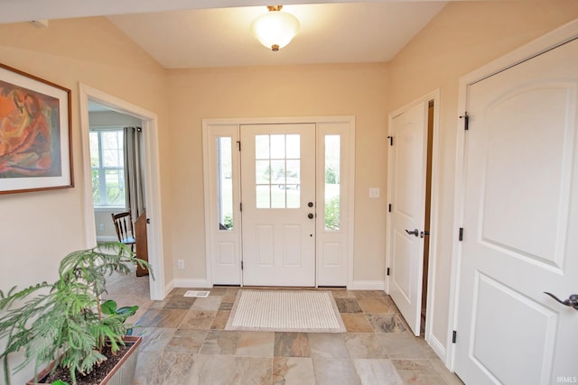 foyer entrance with baseboards, stone finish flooring, and visible vents