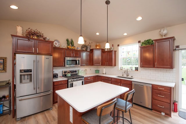 kitchen with backsplash, stainless steel appliances, a sink, and light wood-type flooring