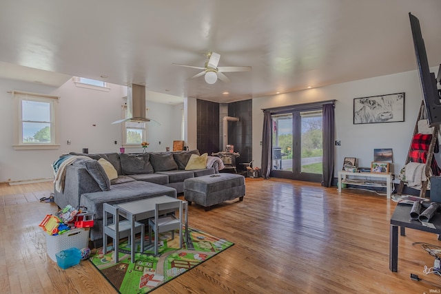living room with ceiling fan, a healthy amount of sunlight, and light wood-type flooring