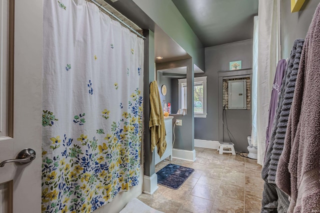 full bath featuring baseboards, electric panel, and curtained shower