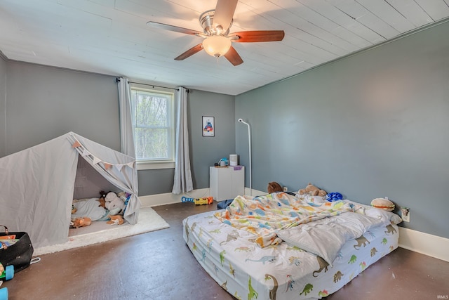 bedroom featuring finished concrete flooring, baseboards, and ceiling fan