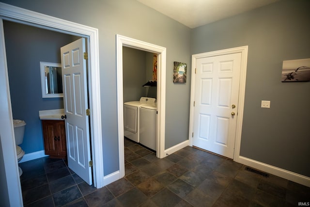 10220 6b Rd, Plymouth, IN 46563 - hallway with washer and clothes dryer, baseboards, and dark stone finish floors