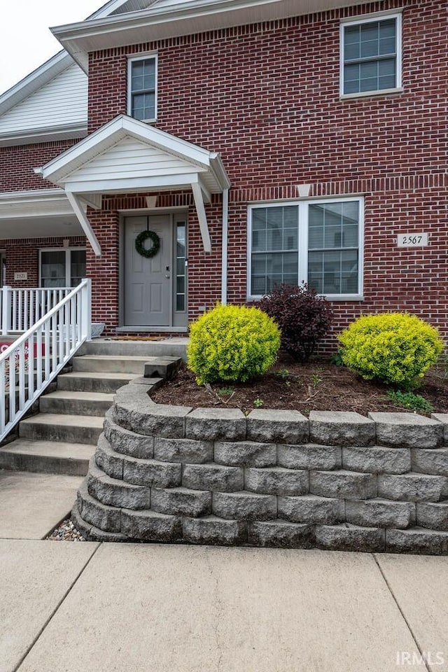 view of exterior entry featuring brick siding