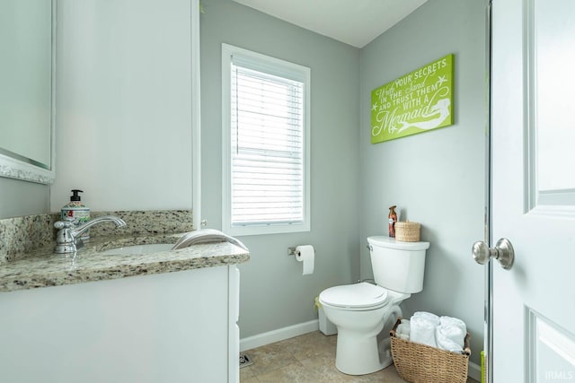 half bath featuring toilet, baseboards, a healthy amount of sunlight, and vanity
