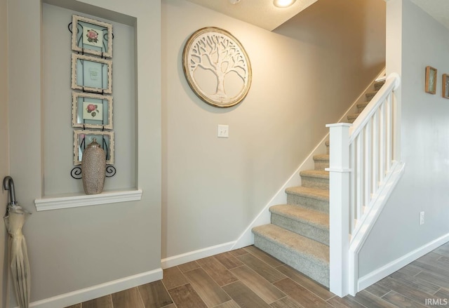 stairway with baseboards and wood finished floors