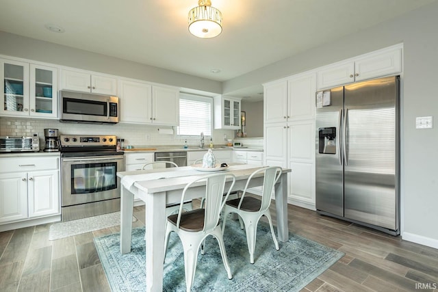 kitchen featuring a toaster, white cabinets, and stainless steel appliances