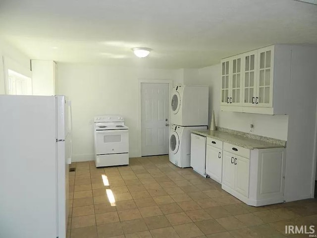 414 17th St, Bedford, IN 47421 - kitchen featuring light countertops, white cabinets, stacked washer / dryer, and white appliances