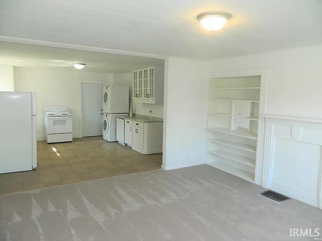 414 17th St, Bedford, IN 47421 - kitchen featuring white appliances, white cabinetry, stacked washer / dryer, visible vents, and glass insert cabinets