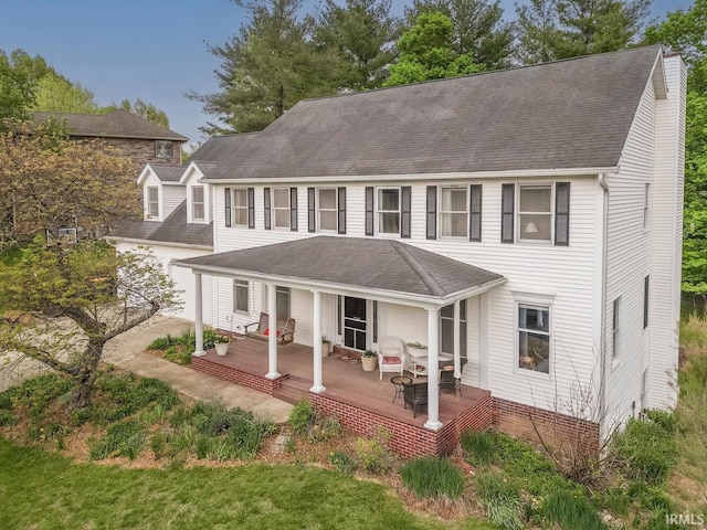 view of front of home featuring a garage, a shingled roof, and covered porch