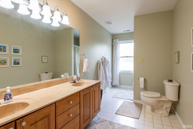 bathroom with a sink, tile patterned floors, baseboards, and toilet