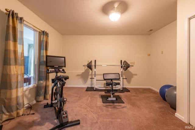 workout room featuring baseboards and carpet