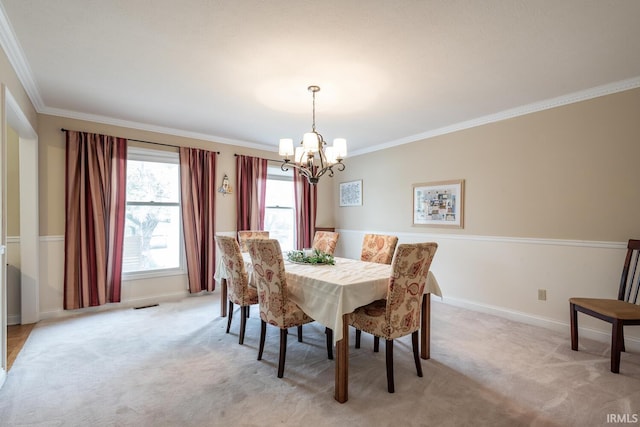 dining area featuring crown molding, baseboards, light carpet, and a notable chandelier