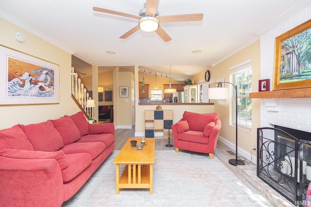 living room featuring stairs, wood finished floors, a fireplace, baseboards, and a ceiling fan
