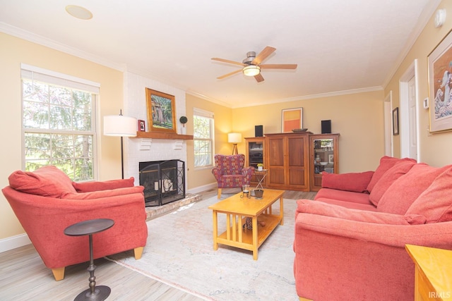living room with light wood-style floors, crown molding, and a fireplace