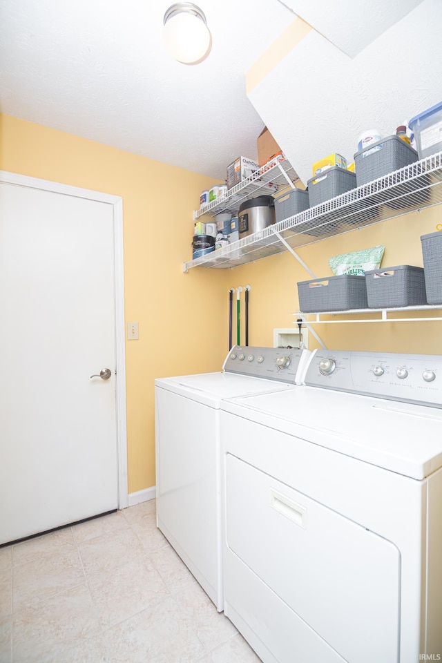 laundry room featuring laundry area, baseboards, light tile patterned floors, and washer and dryer