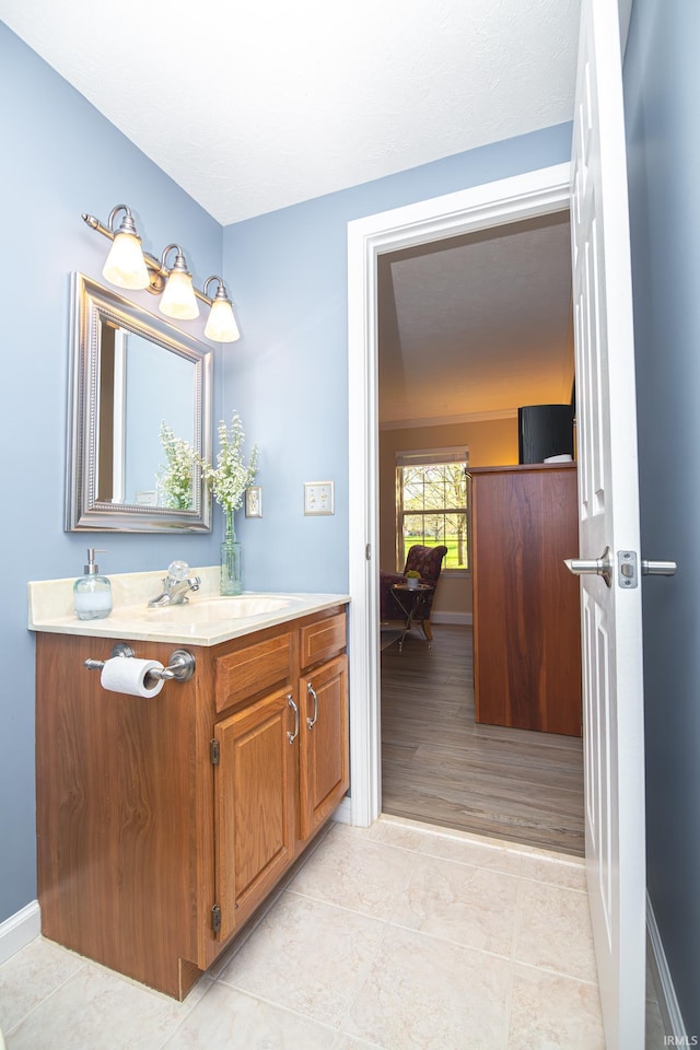 bathroom with vanity, baseboards, and tile patterned flooring