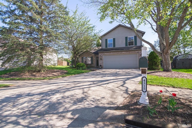 view of front facade featuring a garage, fence, driveway, and brick siding