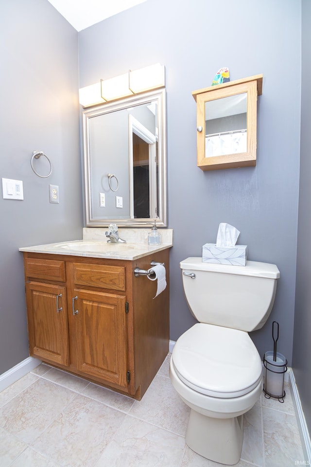 bathroom with baseboards, toilet, and vanity