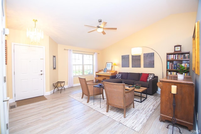 living room featuring visible vents, vaulted ceiling, baseboards, ceiling fan with notable chandelier, and light wood-style flooring