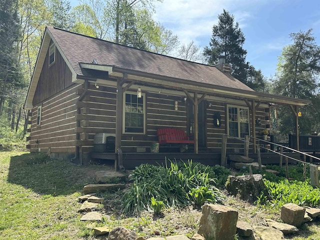 2340 W County Rd 550 S, Paoli, IN 47454 - view of front of home featuring a shingled roof, log exterior, a chimney, and a porch