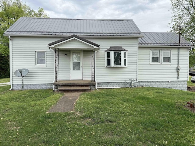 view of front of property with metal roof and a front lawn