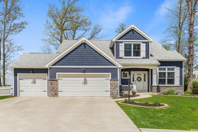 craftsman inspired home featuring a garage, driveway, a front lawn, and stone siding