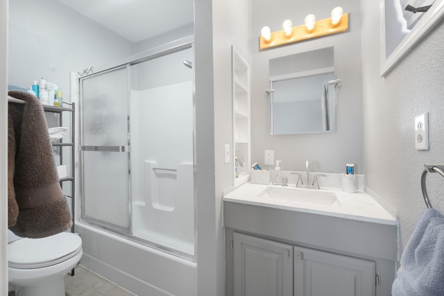 full bathroom featuring toilet, combined bath / shower with glass door, and vanity