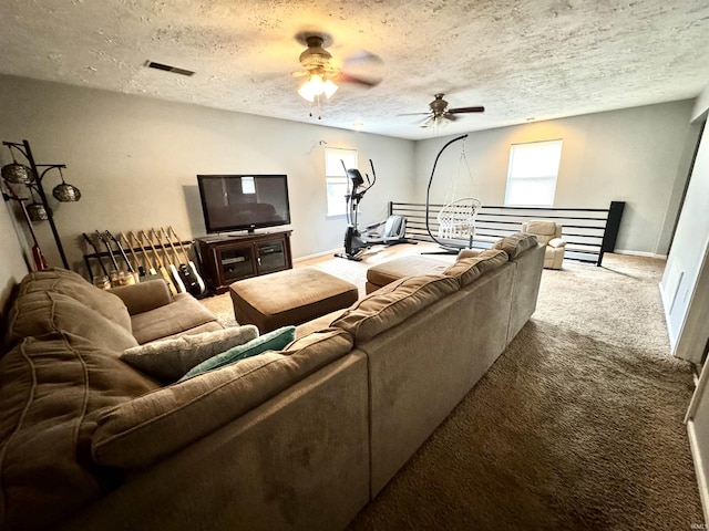 carpeted living room with a textured ceiling, ceiling fan, and a healthy amount of sunlight