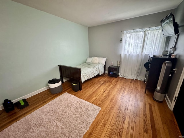 bedroom featuring baseboards and wood finished floors