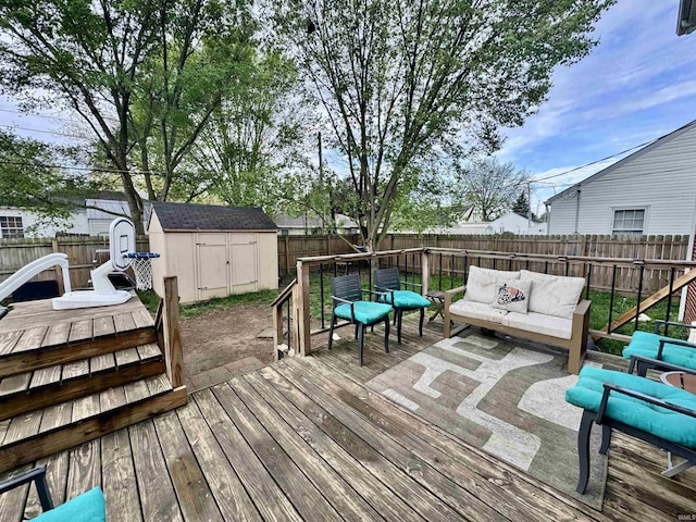deck with an outdoor living space, a fenced backyard, a storage unit, and an outdoor structure