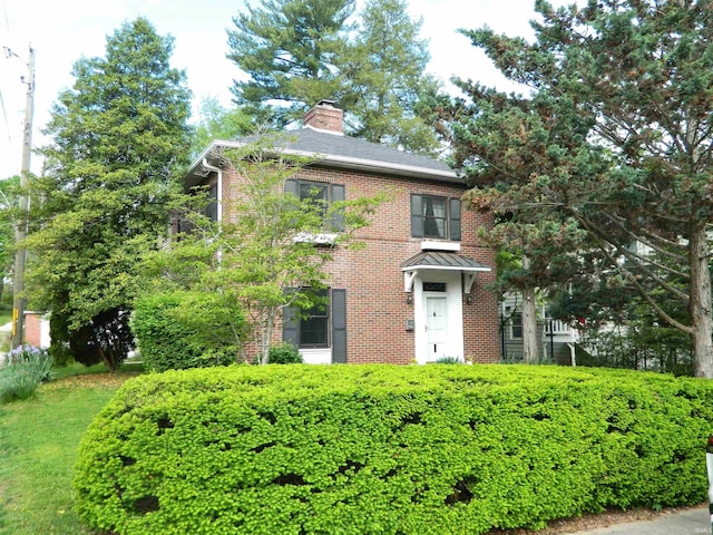 view of front of property with brick siding and a chimney