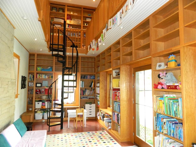 sitting room with plenty of natural light, wood finished floors, and stairway