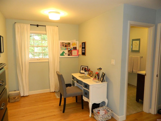 office area with light wood-style floors and baseboards
