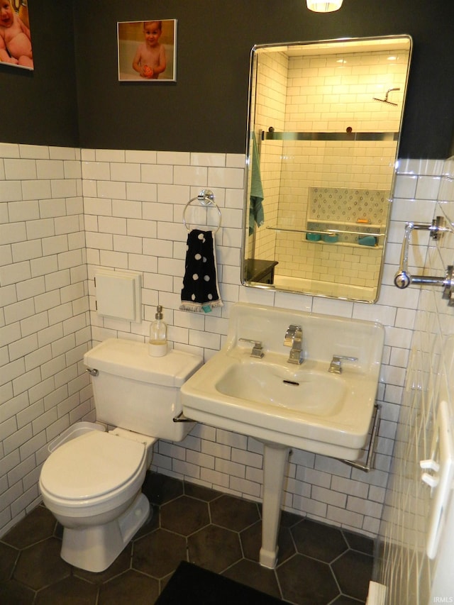 half bathroom featuring toilet, tile walls, and tile patterned flooring
