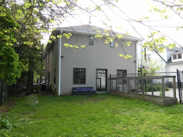 rear view of property with a yard and fence