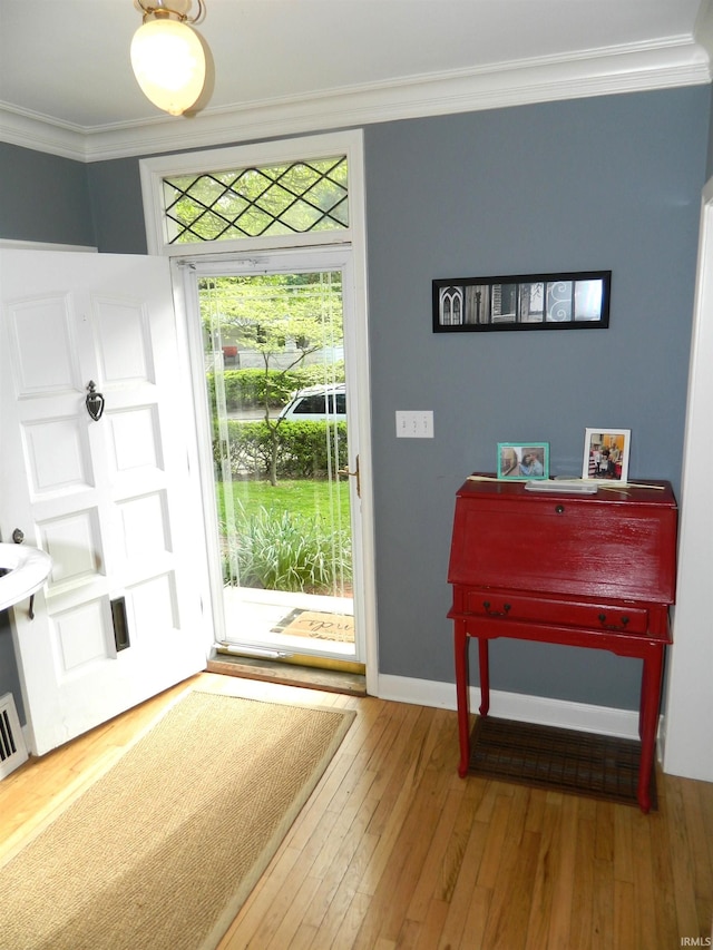 entrance foyer with baseboards, ornamental molding, and hardwood / wood-style floors